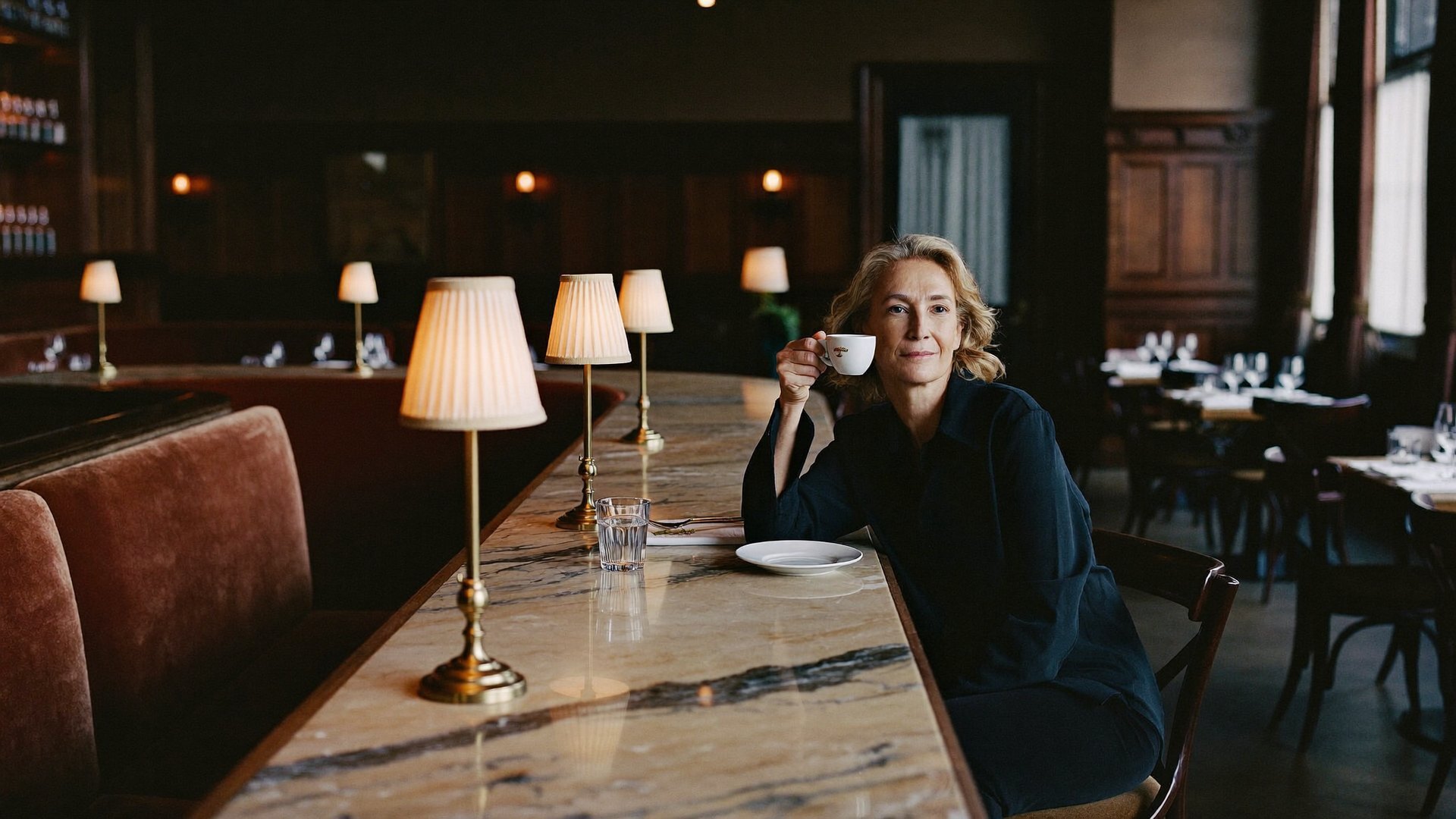 A restaurant owner with an espresso at her own bar before evening service