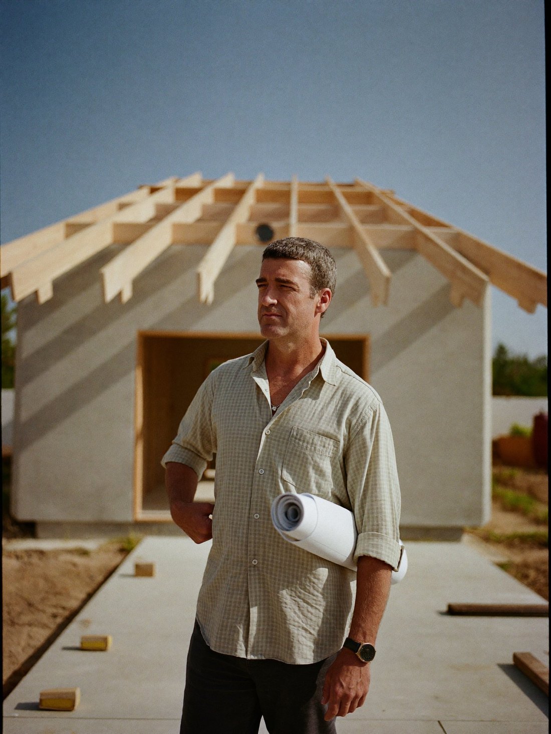 The owner of a construction company on the slab of a house his company is building