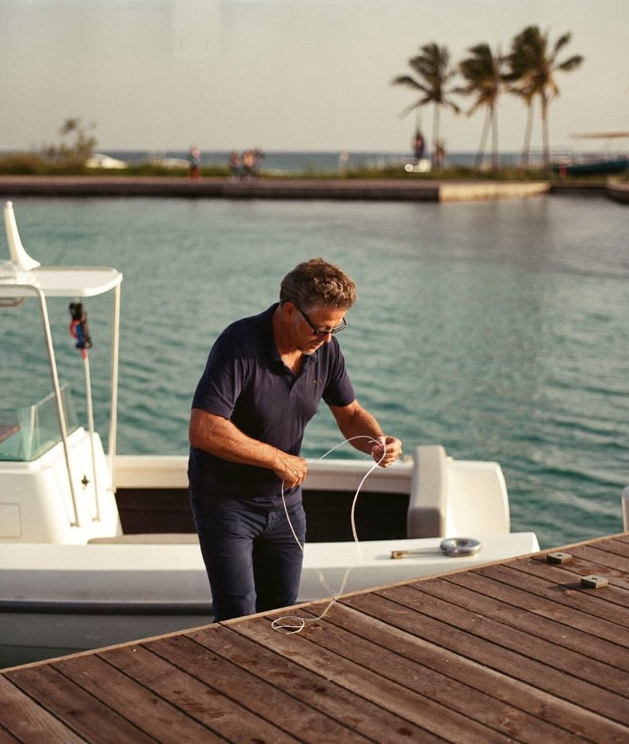 The owner of a charter business coiling a line on his dock in the morning